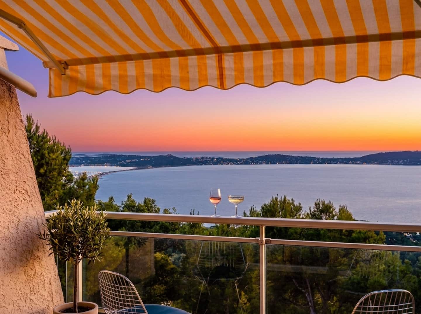 Coucher de soleil sur les Îles d'Or depuis la terrasse du studio à Hyères, deux verres en premier plan